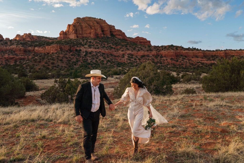 Sedona Elopement couple holding hands with bear mountain behind them.